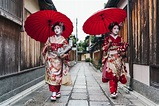 Geishas with red umbrellas in Kyoto's Gion district